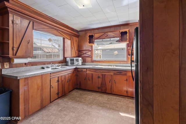 kitchen with brown cabinets, a sink, and light floors