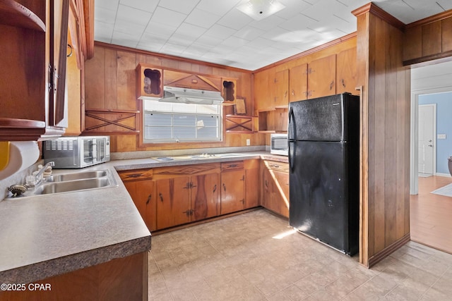 kitchen with light floors, stainless steel microwave, a sink, and freestanding refrigerator