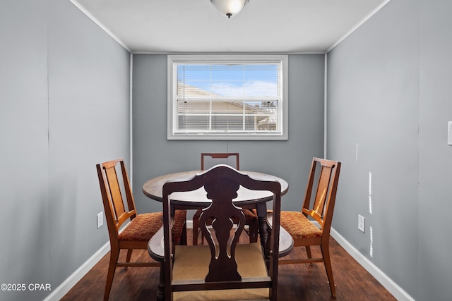 dining area featuring dark wood-style floors, baseboards, and crown molding