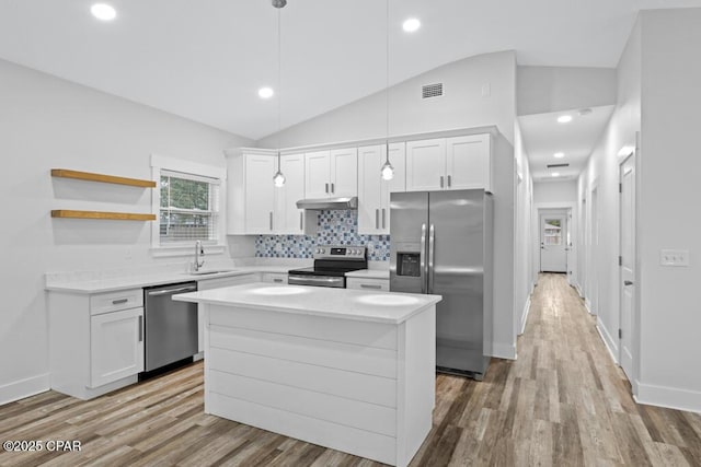 kitchen with visible vents, white cabinets, lofted ceiling, stainless steel appliances, and under cabinet range hood