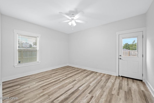 spare room with baseboards, plenty of natural light, and light wood-style floors