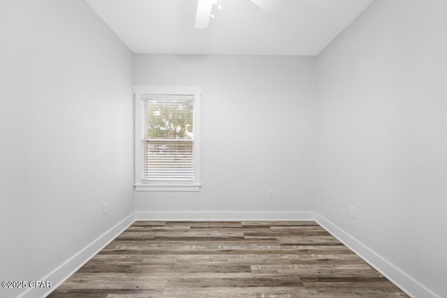 unfurnished room with ceiling fan, wood finished floors, and baseboards