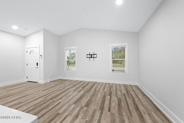 interior space featuring light wood-type flooring, lofted ceiling, baseboards, and recessed lighting