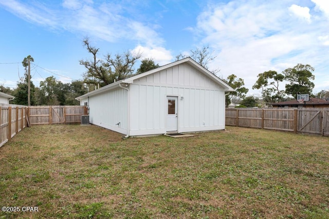 rear view of property with board and batten siding, a fenced backyard, cooling unit, and a yard