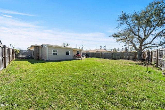 view of yard with central AC and a fenced backyard