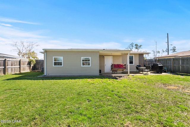 rear view of property with a fenced backyard, a lawn, and a patio