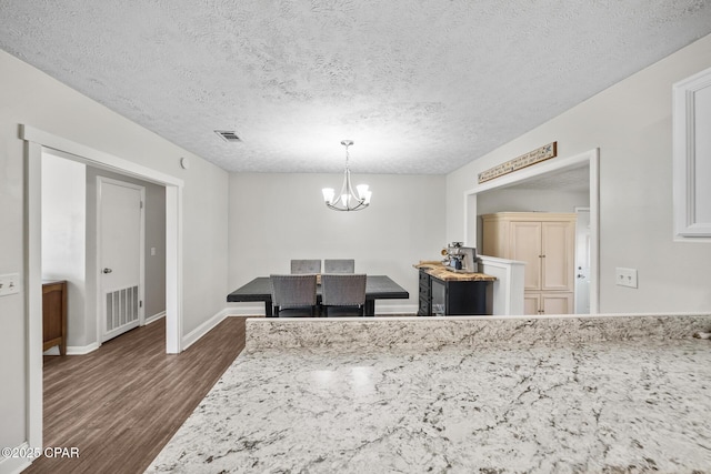 dining room with baseboards, dark wood-style flooring, visible vents, and a notable chandelier