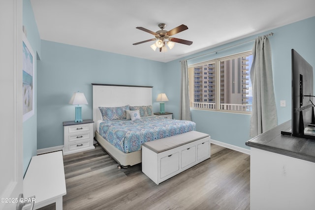 bedroom featuring ceiling fan, wood finished floors, and baseboards