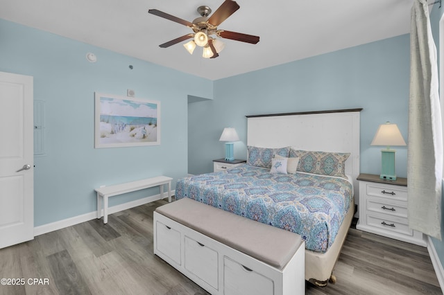 bedroom featuring ceiling fan, baseboards, and wood finished floors