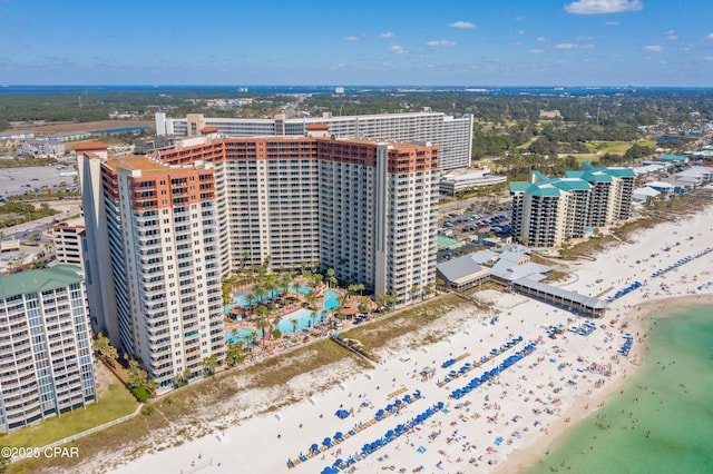 drone / aerial view featuring a water view, a view of city, and a view of the beach