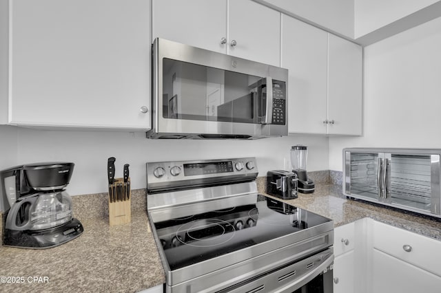 kitchen featuring white cabinets, stainless steel appliances, and light countertops