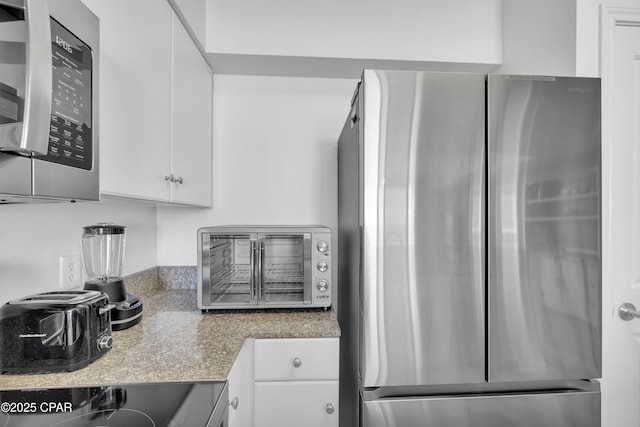 kitchen featuring a toaster, white cabinetry, appliances with stainless steel finishes, and light countertops