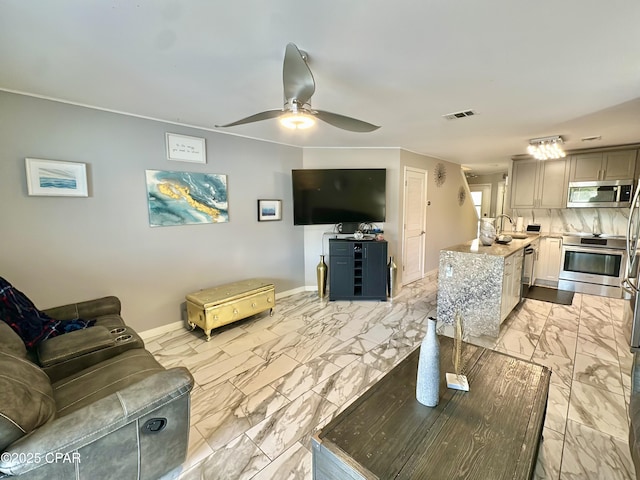 living room with visible vents, marble finish floor, baseboards, and ceiling fan