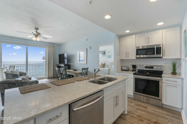 12011 Front Beach Rd Unit 204B, Panama City Beach, FL 32407 - kitchen with stainless steel appliances, a sink, tasteful backsplash, white cabinetry, and recessed lighting