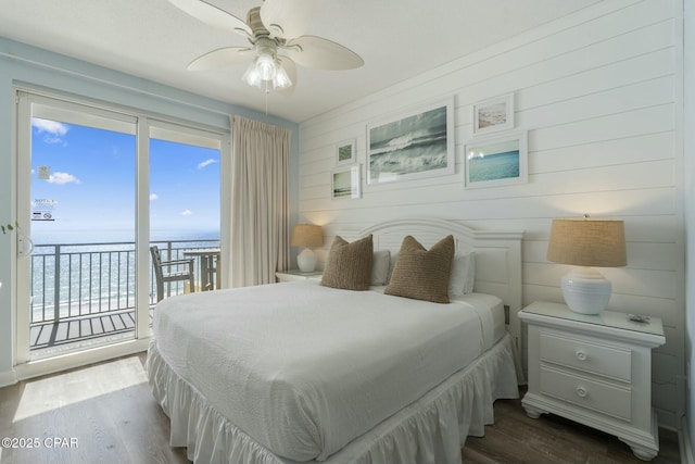 12011 Front Beach Rd Unit 204B, Panama City Beach, FL 32407 - bedroom featuring access to exterior, dark wood-type flooring, a water view, ceiling fan, and wood walls