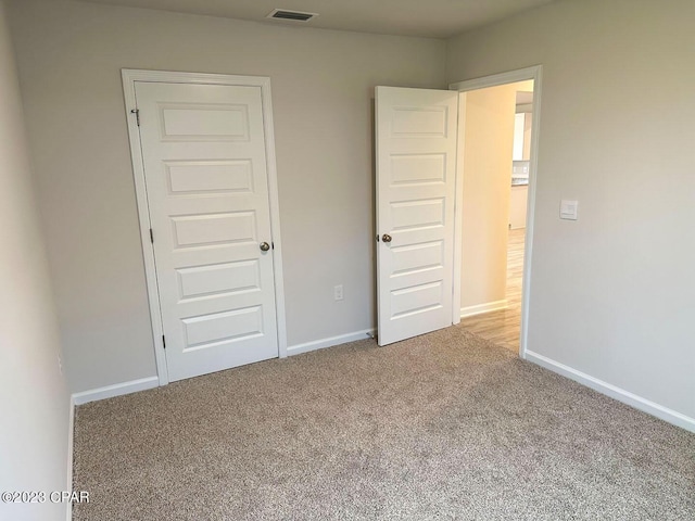 unfurnished bedroom featuring carpet, visible vents, and baseboards