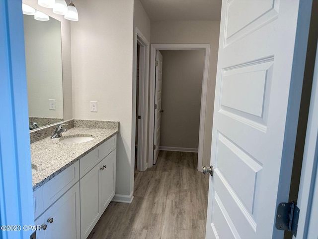 bathroom featuring vanity, baseboards, and wood finished floors