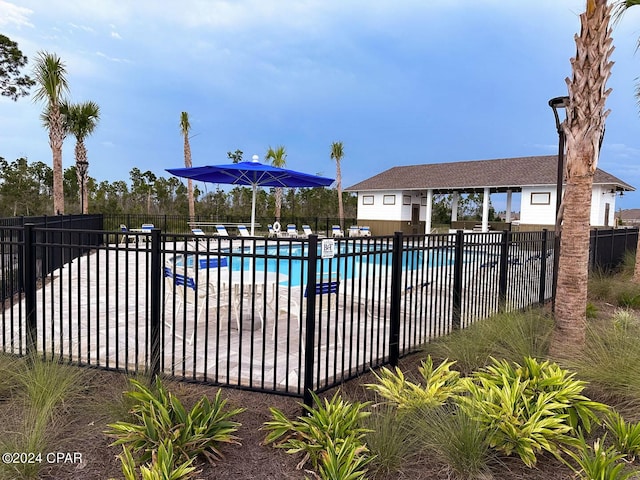 community pool with fence and a patio