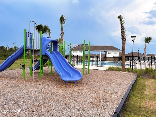 community play area featuring a community pool and fence