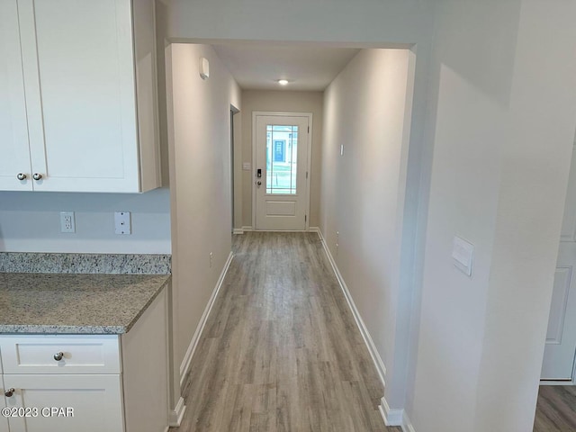 entryway with light wood-style floors and baseboards