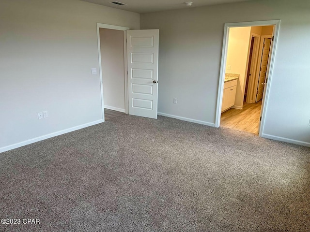 unfurnished bedroom with carpet, visible vents, and baseboards