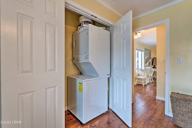 laundry room featuring dark wood-style floors, crown molding, stacked washer / dryer, laundry area, and baseboards