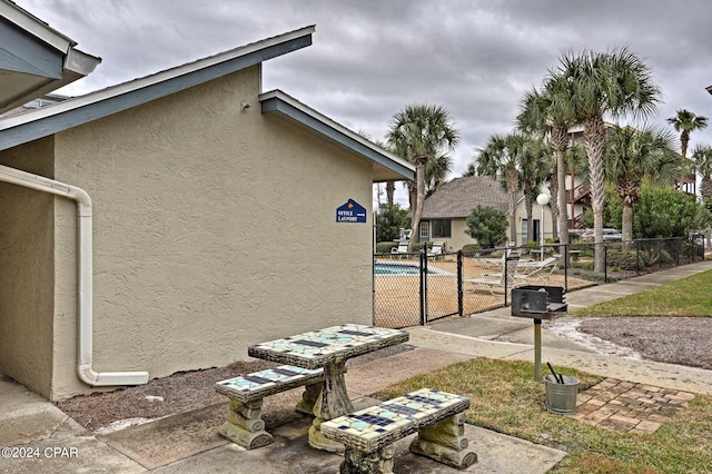 view of property exterior featuring fence, a gate, and stucco siding