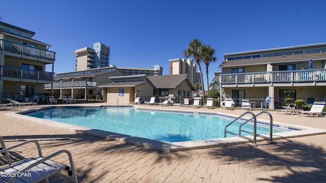 pool with a patio and fence