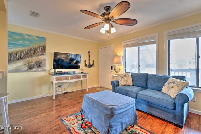 living area featuring crown molding, a wealth of natural light, and wood finished floors