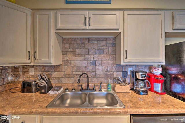 kitchen with tasteful backsplash, light countertops, a sink, and dishwashing machine