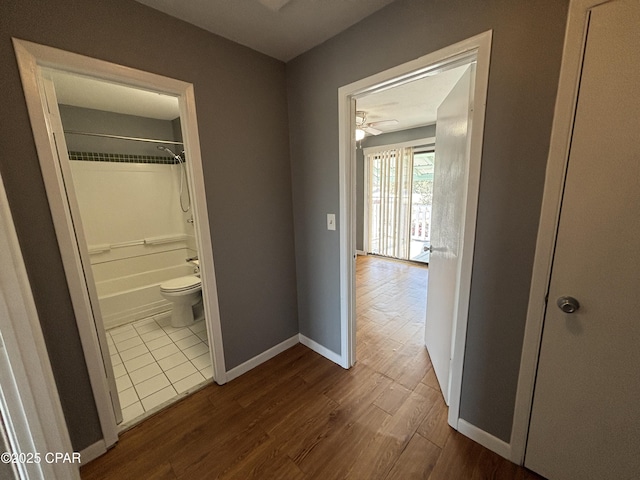 hallway featuring baseboards and dark wood-type flooring