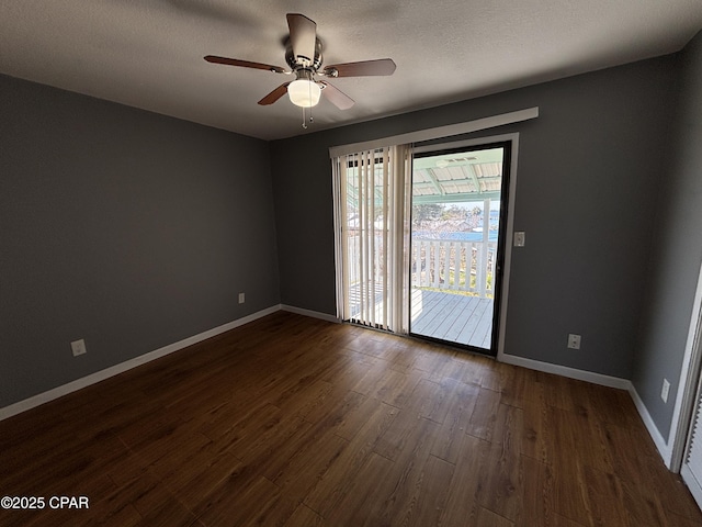 spare room featuring ceiling fan, dark wood-type flooring, a textured ceiling, and baseboards