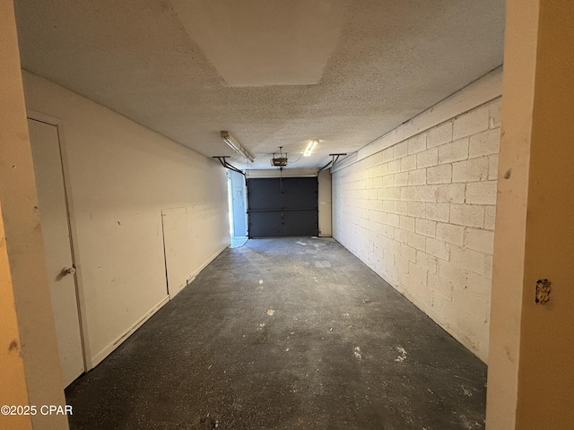 garage with concrete block wall and a garage door opener