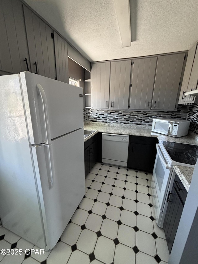 kitchen featuring light floors, white appliances, gray cabinets, and decorative backsplash