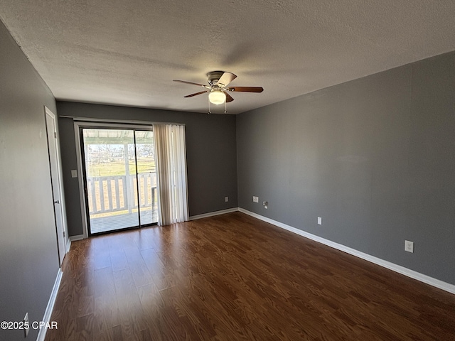 unfurnished room featuring dark wood-style floors, ceiling fan, a textured ceiling, and baseboards