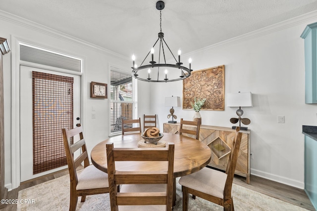 dining room featuring light wood finished floors, a notable chandelier, baseboards, and ornamental molding