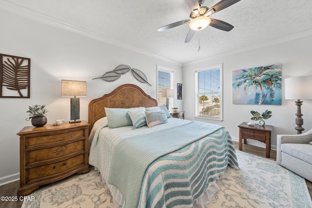 bedroom with crown molding, light wood-type flooring, baseboards, and a textured ceiling