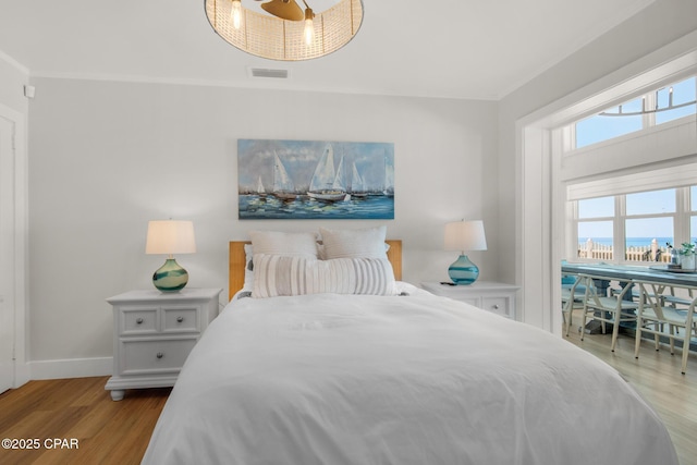 13011 Oleander, Panama City Beach, FL 32407 - bedroom with ornamental molding, visible vents, baseboards, and wood finished floors