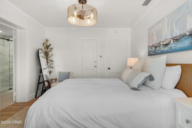 13011 Oleander, Panama City Beach, FL 32407 - bedroom with visible vents, ensuite bathroom, light wood-style floors, a ceiling fan, and ornamental molding