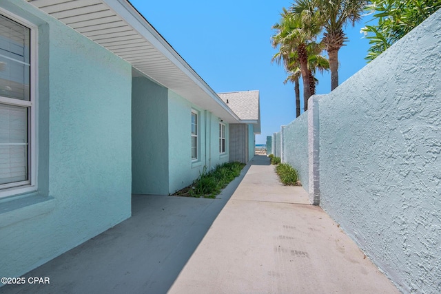 13011 Oleander, Panama City Beach, FL 32407 - view of side of home with fence, a patio, and stucco siding