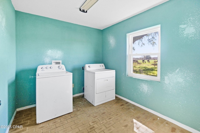 washroom with baseboards, laundry area, brick floor, and washer and dryer