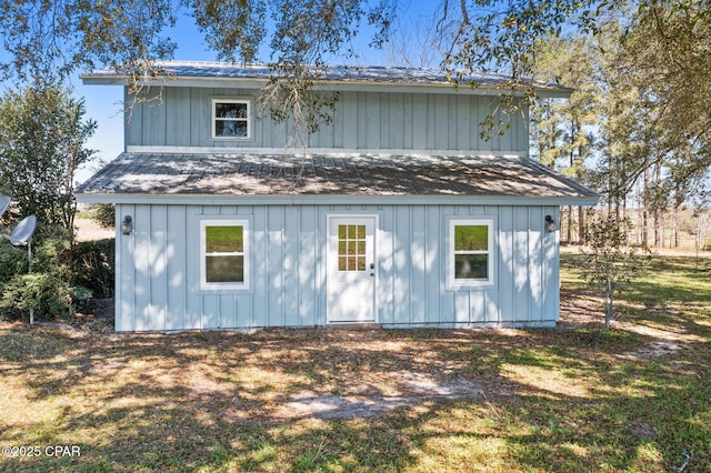 back of property featuring board and batten siding and metal roof