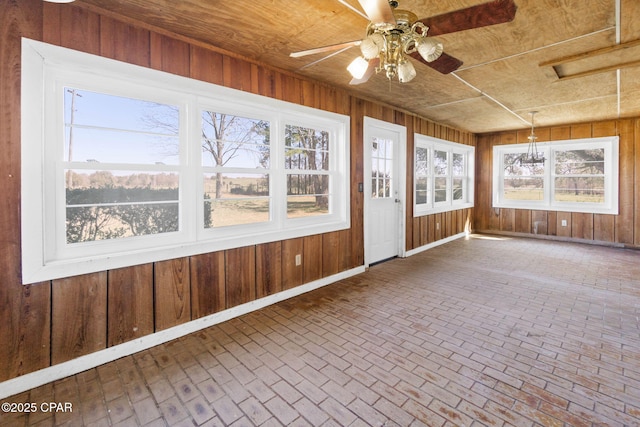 unfurnished sunroom featuring wooden ceiling and a ceiling fan