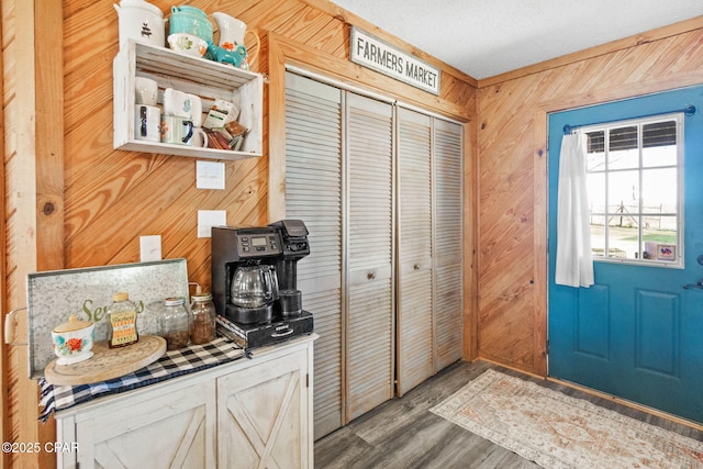 interior space featuring open shelves, wooden walls, and wood finished floors