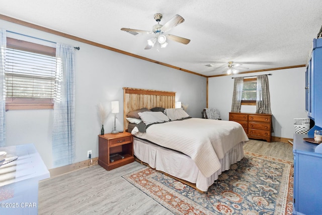 bedroom with baseboards, light wood-style floors, crown molding, and a textured ceiling