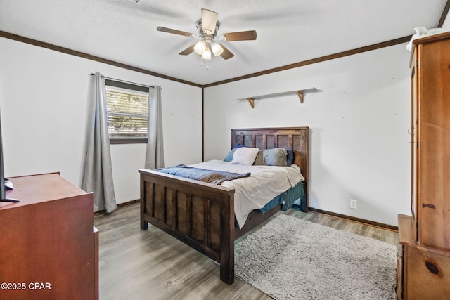 bedroom with ceiling fan, crown molding, light wood-type flooring, and baseboards