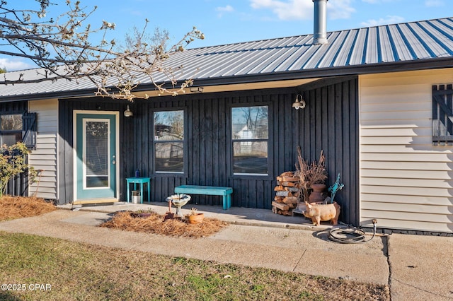 rear view of house with metal roof and board and batten siding