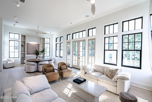 living room with ceiling fan, baseboards, wood finished floors, and french doors