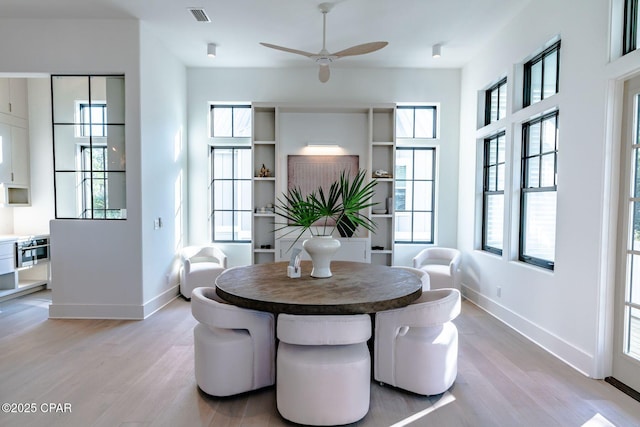 dining space featuring ceiling fan, light wood-type flooring, visible vents, and baseboards