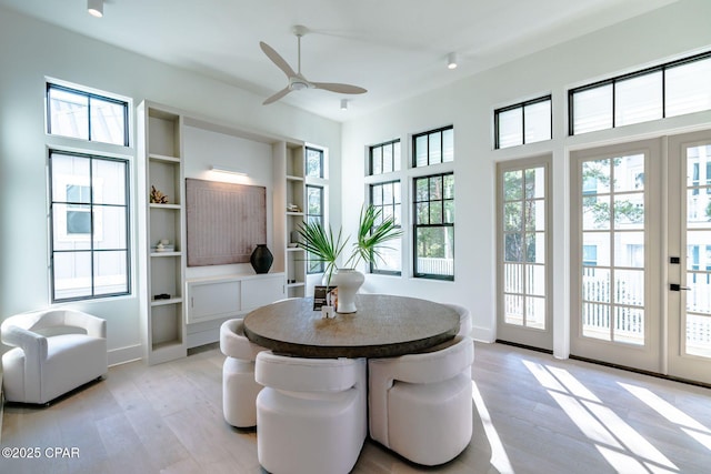 dining room with ceiling fan, light wood-style flooring, and baseboards